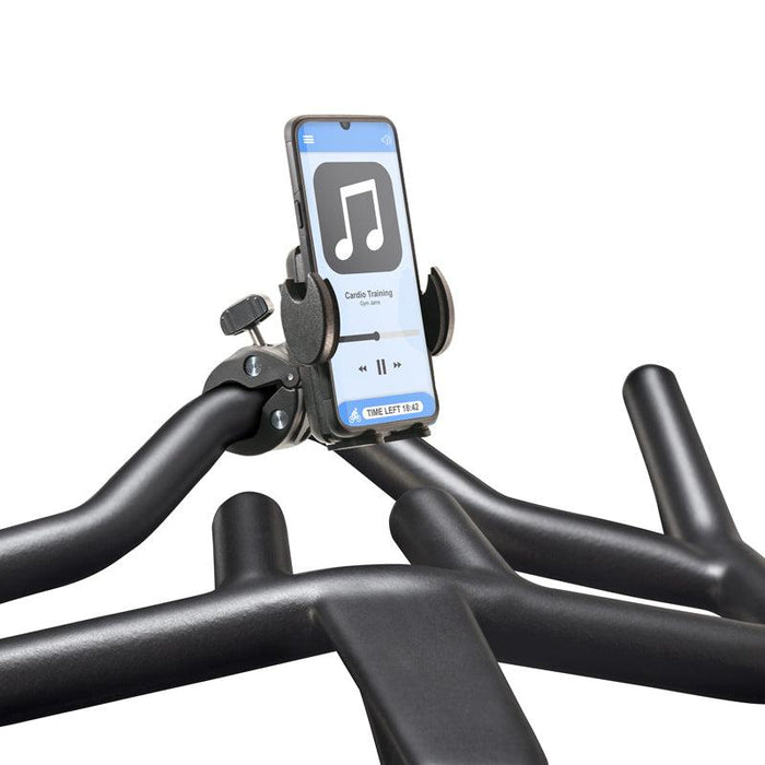 Close-up of a Mega Grip™ Phone Holder with Clamp Mount securing a smartphone to a stationary bike handlebar; the phone displays a music app with a musical note icon and “Cardio Training” text.