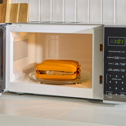 Toastie Maker inside a microwave oven on a kitchen counter.