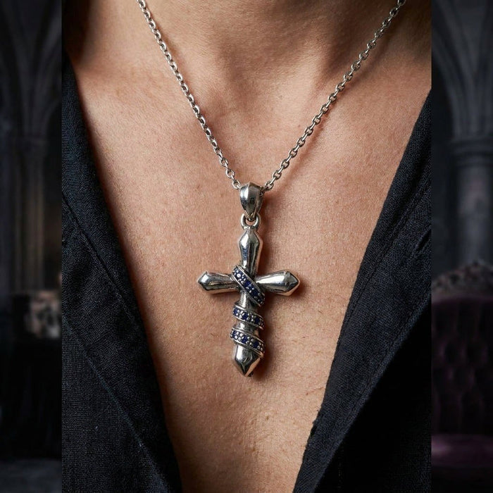 On-model view of the 40mm silver cross pendant resting on the chest, highlighting the blue CZ chain wrap detail.
