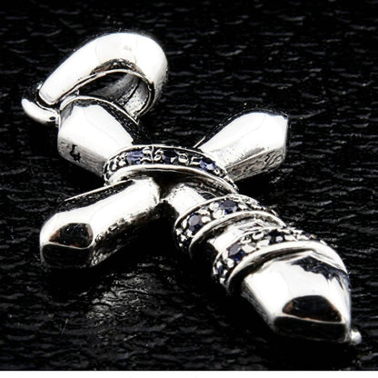 Angled close-up of the polished silver cross, emphasizing the sculpted chain relief and inset blue cubic zirconia stones.