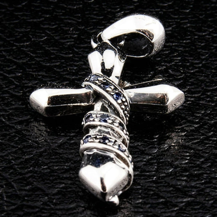Full pendant view resting on a black textured background, highlighting the polished silver bail and blue stone chain wrap.