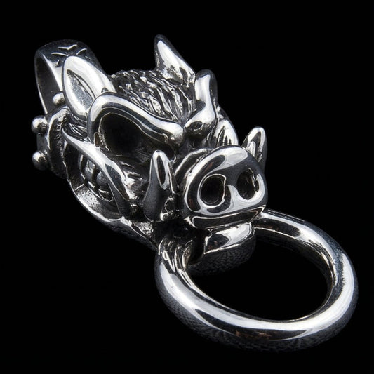 Close up of snarling boar pendant showing detailed silver tusks and ring in mouth