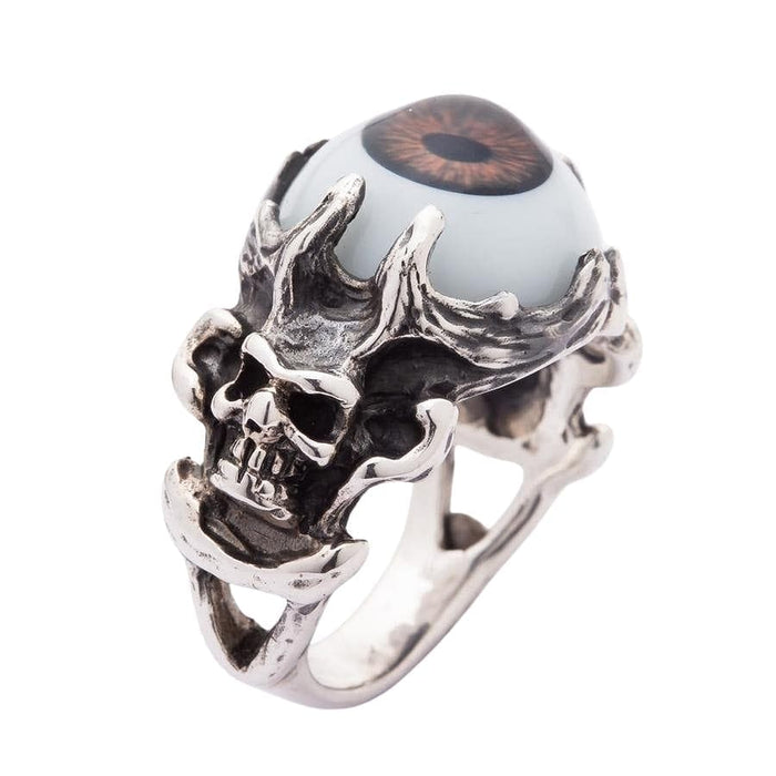 A side-angle view of the gothic skull eyeball ring, showing the deep, macabre carving of the skull and bone band.