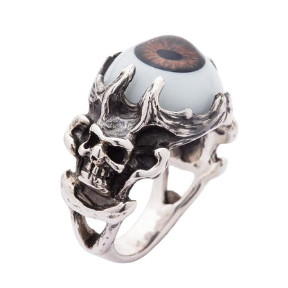 A side-angle view of the gothic skull eyeball ring, showing the deep, macabre carving of the skull and bone band.