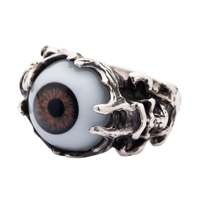 A detailed shot of the silver devil skull ring, focusing on the oxidized skull and brown eyeball.