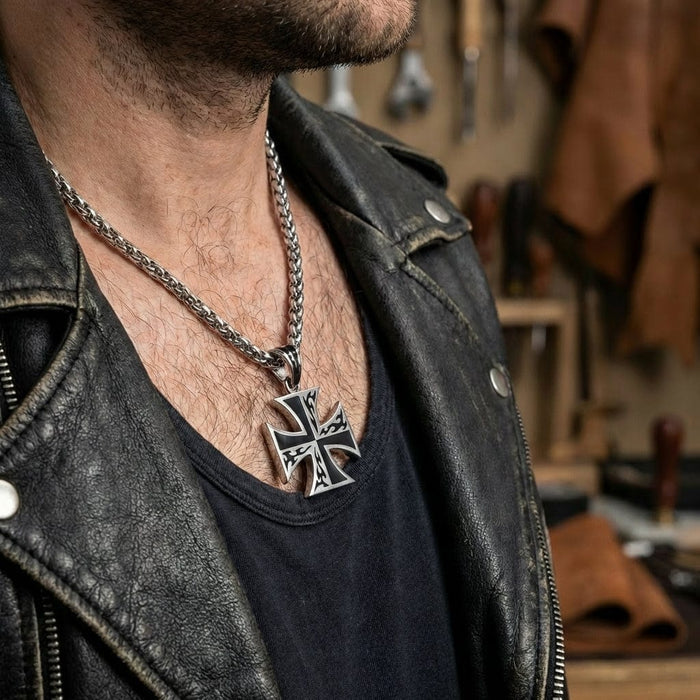 Sterling silver flame iron cross pendant necklace with tribal flame design worn by man in black leather biker jacket, featuring heavy wheat chain and rugged masculine style