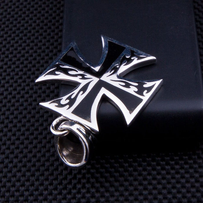 An angled shot of the flame iron cross pendant, emphasizing the shine of the sterling silver against the deep black inlay.