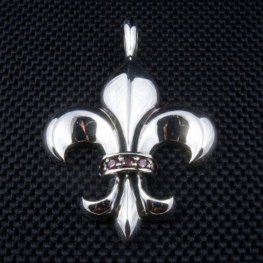 Fleur de lis sterling silver pendant with red garnet stones center band front view on black textured background
