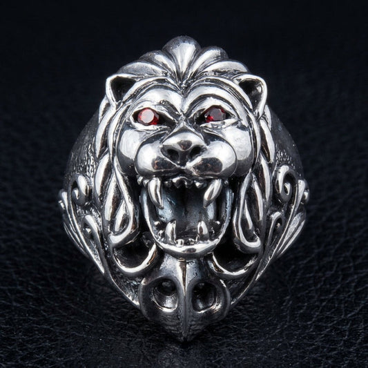 Sterling silver lion head ring with red garnet eyes front view showing roaring lion face and detailed mane
