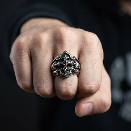 Man wearing gothic shield sterling silver ring with garnet CZ stone on middle finger showing fist pose