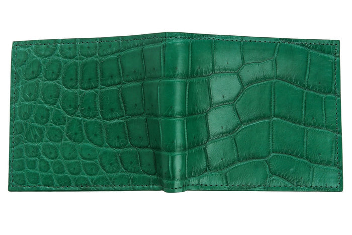 The green crocodile wallet laid open flat to show the full exterior bifold spine and scale texture.