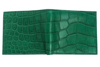 The green crocodile wallet laid open flat to show the full exterior bifold spine and scale texture.