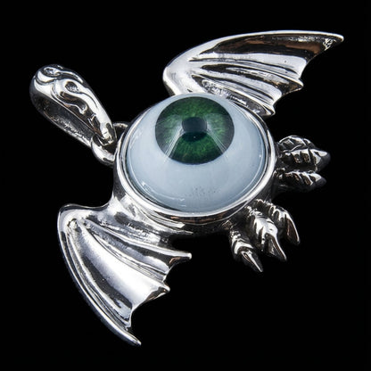 Angled view of sterling silver bat pendant with green polymer eye