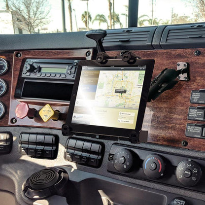 A LockVise™ Locking Drill Base Tablet Mount with Key Lock for E-Log securely holds a tablet displaying a map app on a truck dashboard, surrounded by controls and wood paneling, as sunlight reflects off the tablet screen.