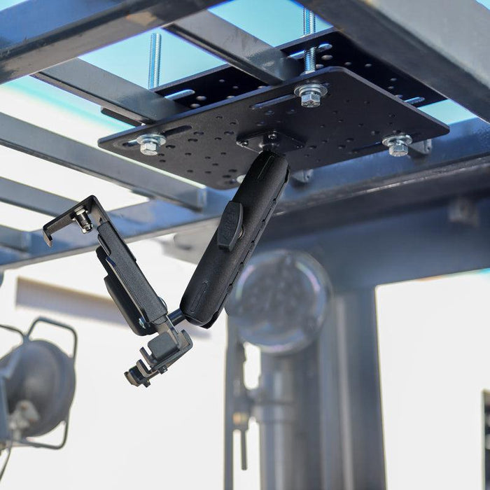 A close-up of the LockVise™ Metal Locking Forklift Overhead Guard Tablet Mount with 6 Shaft attached to a metal rack, designed to securely hold a tablet. Outdoor lighting equipment is visible in the background.