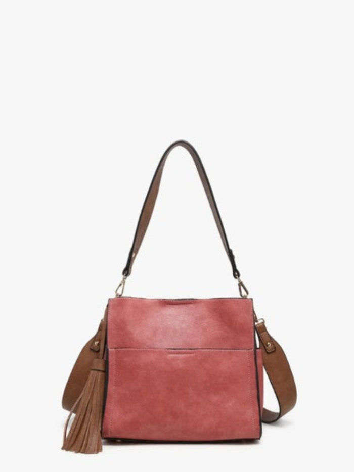 A dusty rose pink faux-leather shoulder bag with brown leather straps and a matching tassel detail, shown against a plain white background.