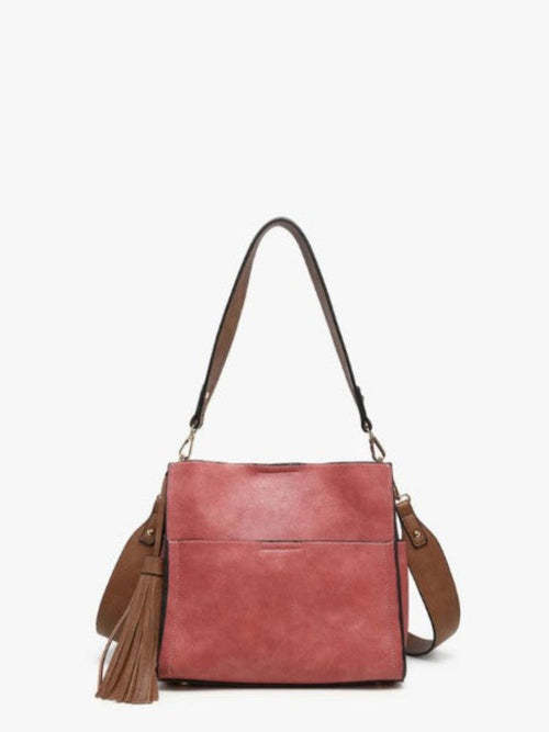 A dusty rose pink faux-leather shoulder bag with brown leather straps and a matching tassel detail, shown against a plain white background.