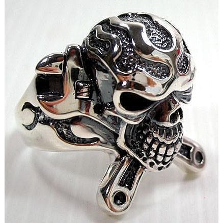 Crossed wrenches sit behind the skull, flame patterns darkened in the recesses across the polished band.