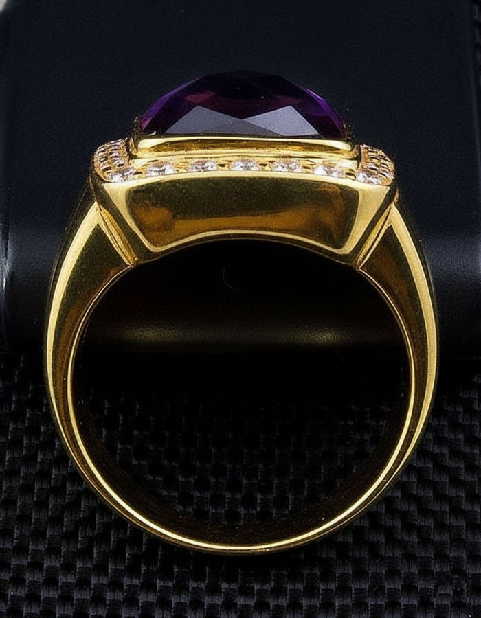 Side profile of the polished band where small clear stones ring the deep purple faceted centre.
