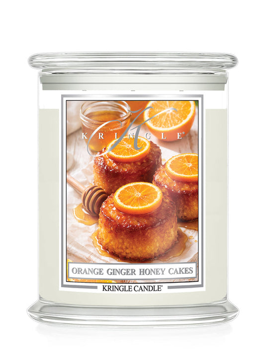 Kringle Candle with a label featuring Orange Ginger Honey Cakes on a white background
