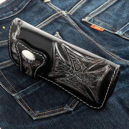 A unique custom leather wallet with a ghostly phantom skull motif, shown resting on a dark denim background.