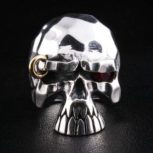 A premium punk-style red eye skull ring, featuring a rugged, faceted texture and a rebellious gold piercing.