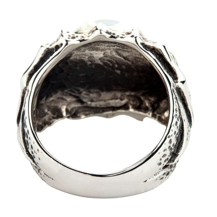 Low side angle detailing the rugged, pitted texture of the heavy sterling silver shank and the bulging crimson polymer eye.