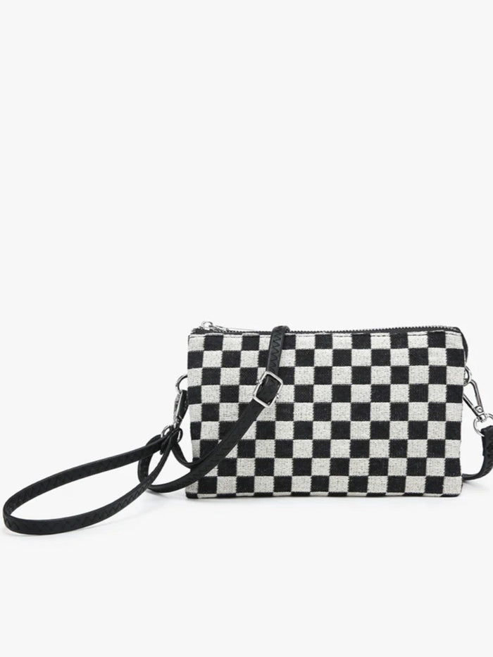 A small black and white checkered crossbody clutch bag with a black wrist strap and silver-tone hardware, shown against a plain white background.