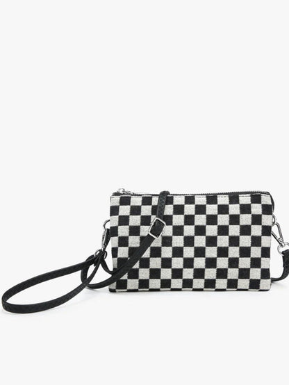 A small black and white checkered crossbody clutch bag with a black wrist strap and silver-tone hardware, shown against a plain white background.
