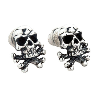 Angled close-up of handcrafted silver skull earrings showing oxidized finish