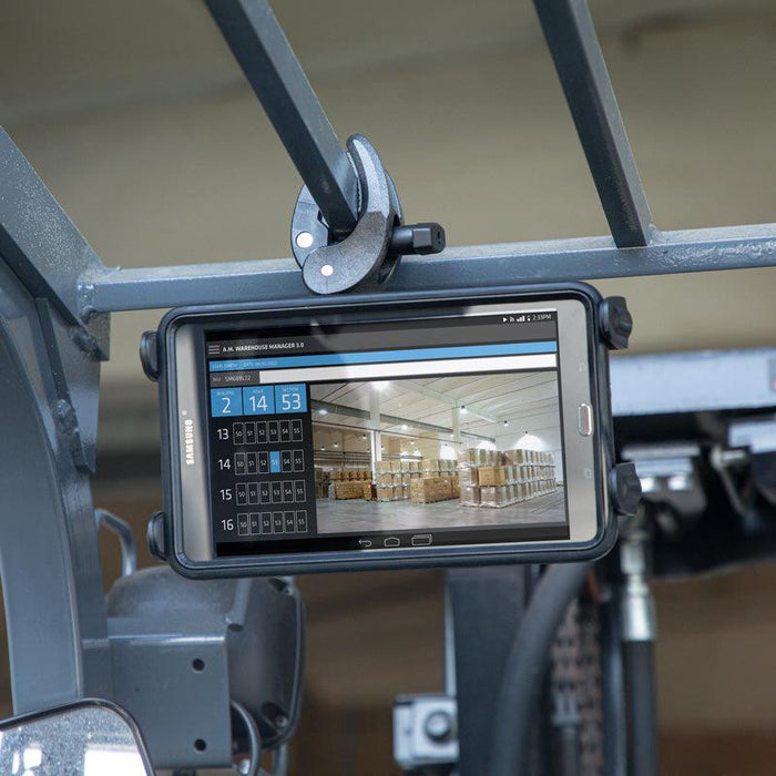 The Slim-Grip® Tablet Holder with Clamp Mount and Security Knob Shaft secures a tablet to industrial equipment, displaying warehouse management software with a calendar and a warehouse image filled with pallets.