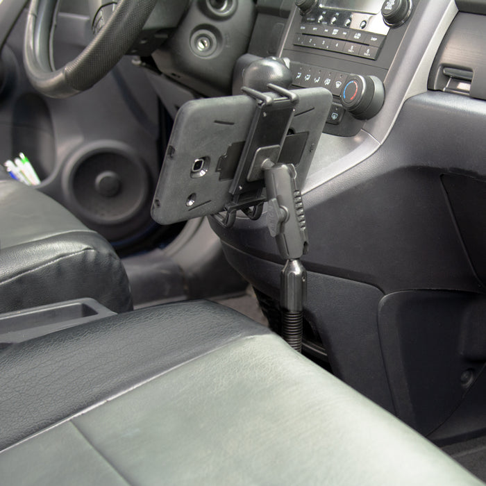 A Slim-Grip® Ultra Phone Seat Rail or Floor Car Truck Mount holds a smartphone near the driver’s seat, with the steering wheel and car controls visible in the background.