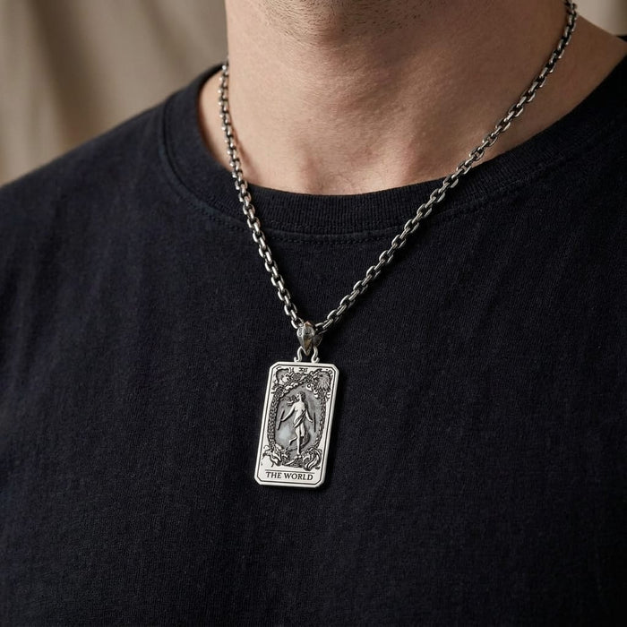 Male model in black shirt wearing a silver World tarot card pendant necklace.