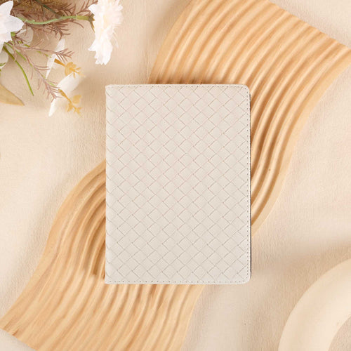 White woven kindle case on a beige surface with floral elements